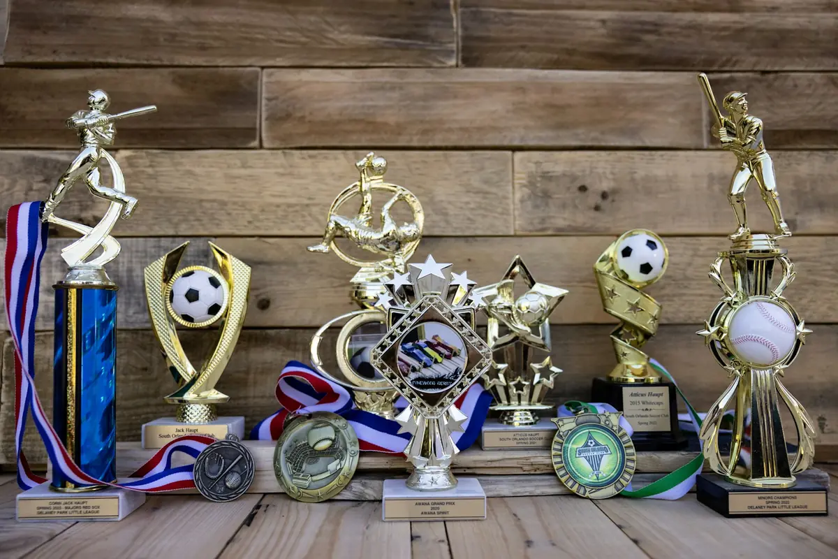 Trofeos y medallas deportivas sobre una mesa de madera.