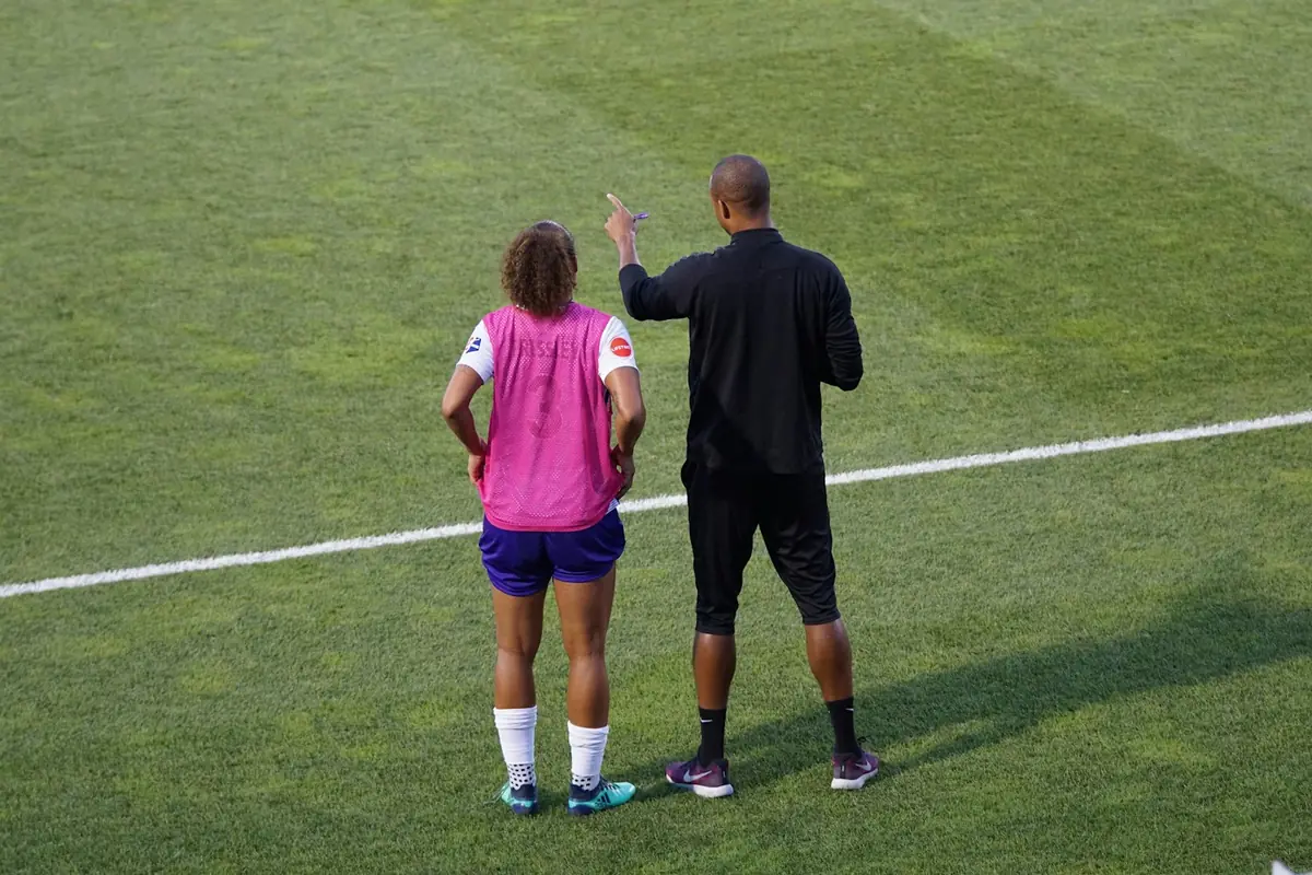 Un entrenador da indicaciones a una jugadora durante el entrenamiento.