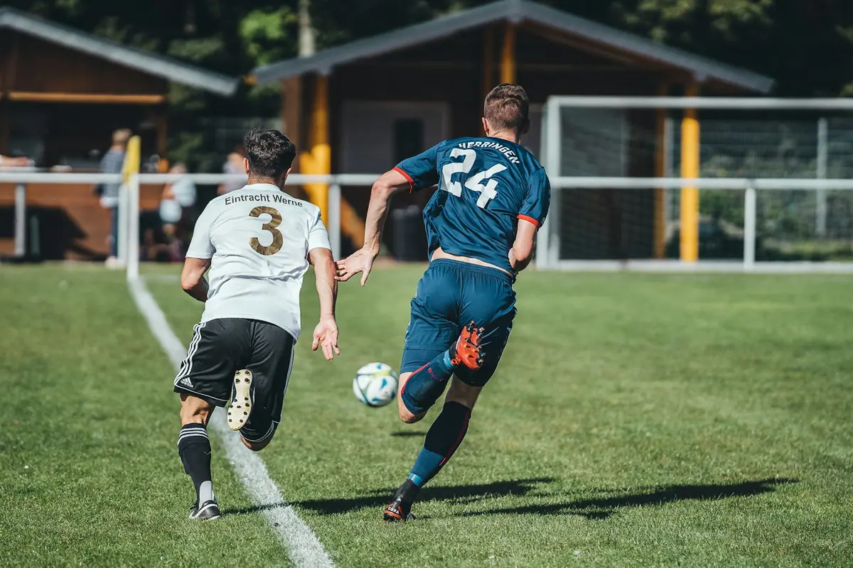 Dos futbolistas disputan el balón durante un partido.